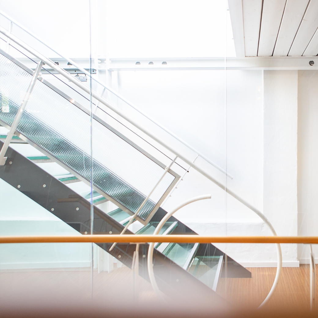 Moderne Treppe fÃ¼hrt nach oben in ein helles BÃ¼ro