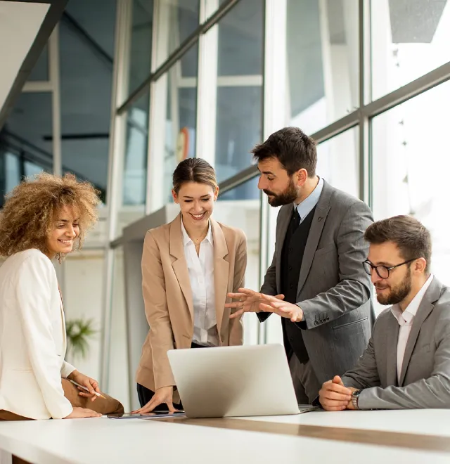 Modernes Gebäude mit großen Glasfenstern, Sonnenstrahlen, umgeben von Bäumen