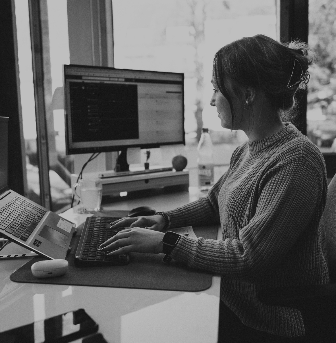Junge Frau sitzt in einem Schreibtisch im modernen Büro und arbeitet konzentriert