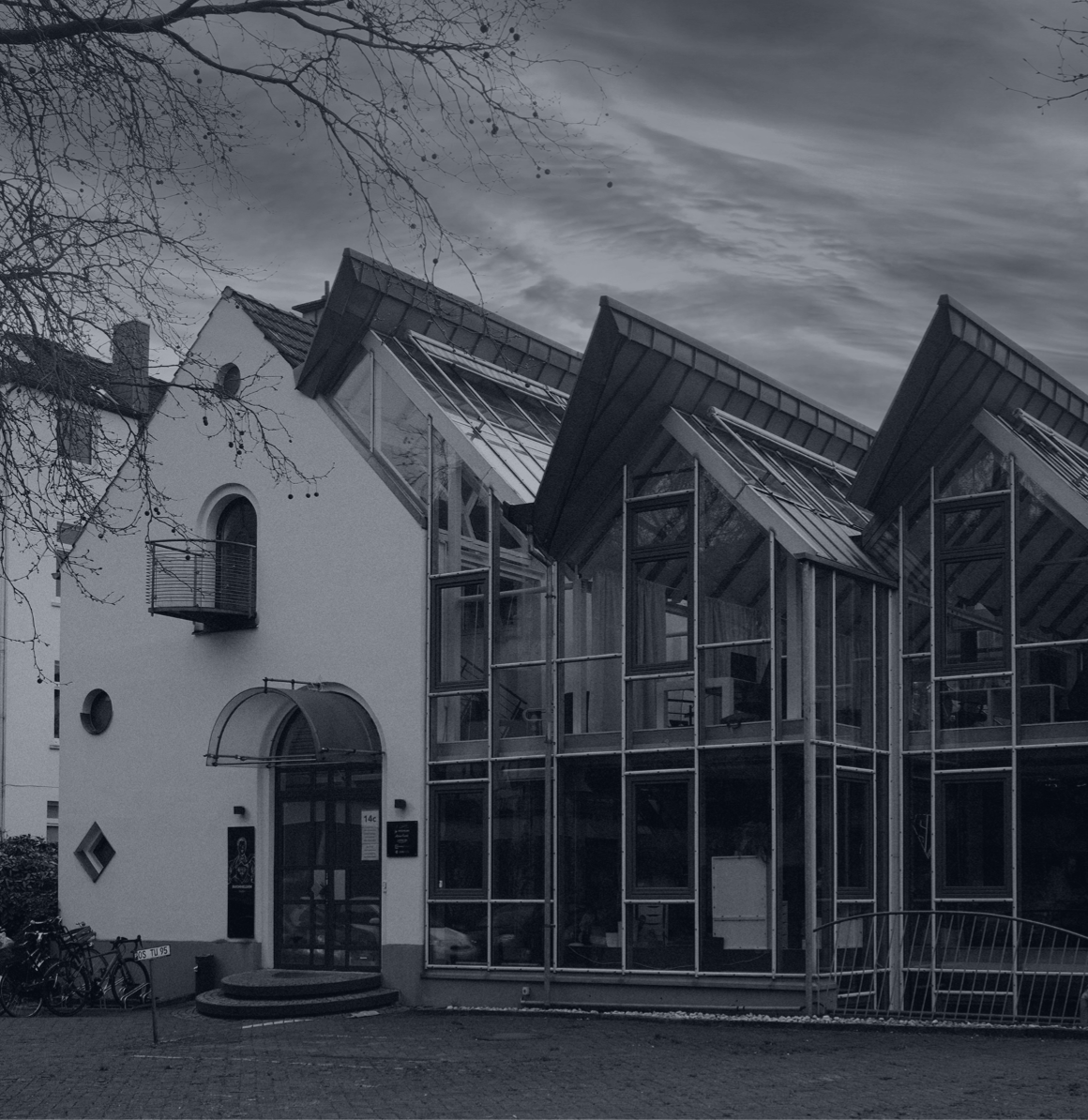 Modernes Bürogebäude mit Glasfassade und markanten schrägen Dachflächen