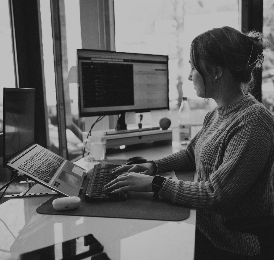 Junge Frau sitzt in einem Schreibtisch im modernen Büro und arbeitet konzentriert